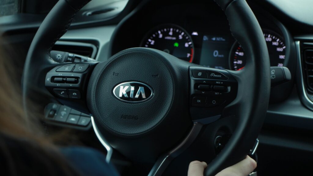 Руль KIA, за который держится человек