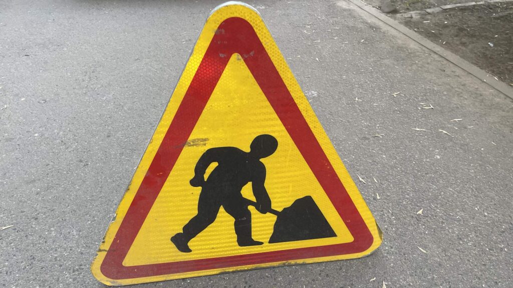 Знак ремонтных работ стоит на дороге
