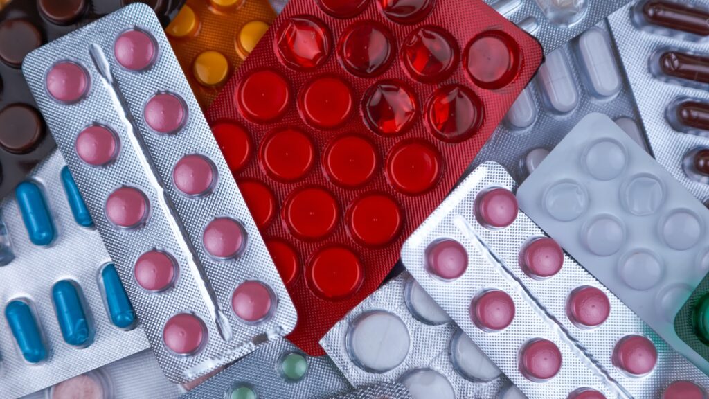 Лекарства в упаковках разбросаны на столе