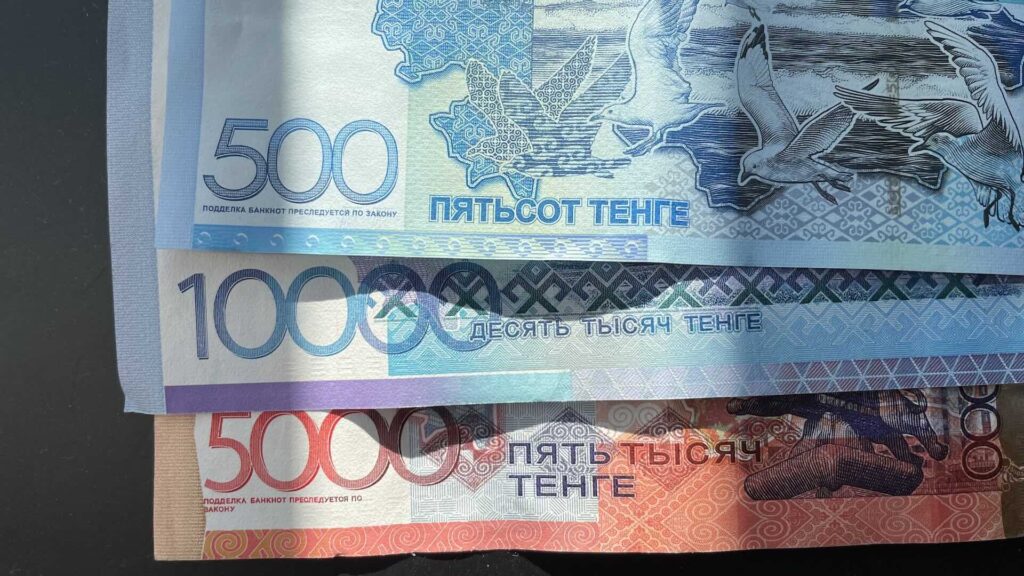 Купюры в 500, 5000 и 10000 тенге лежат на столе