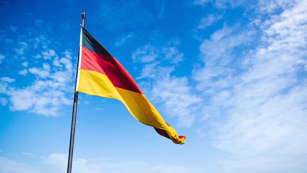 Флаг Германии развивается на фоне голубого неба