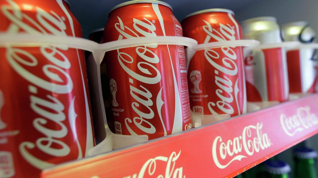 Жестяные банки Coca-Cola на прилавке в магазине