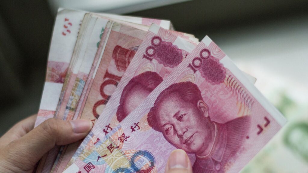 Купюры китайского юаня в руках