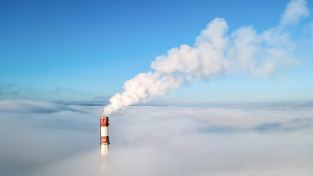 Дым выходит из трубы ТЭЦ выше облаков