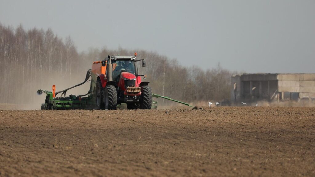 Трактор сеет семена на поле