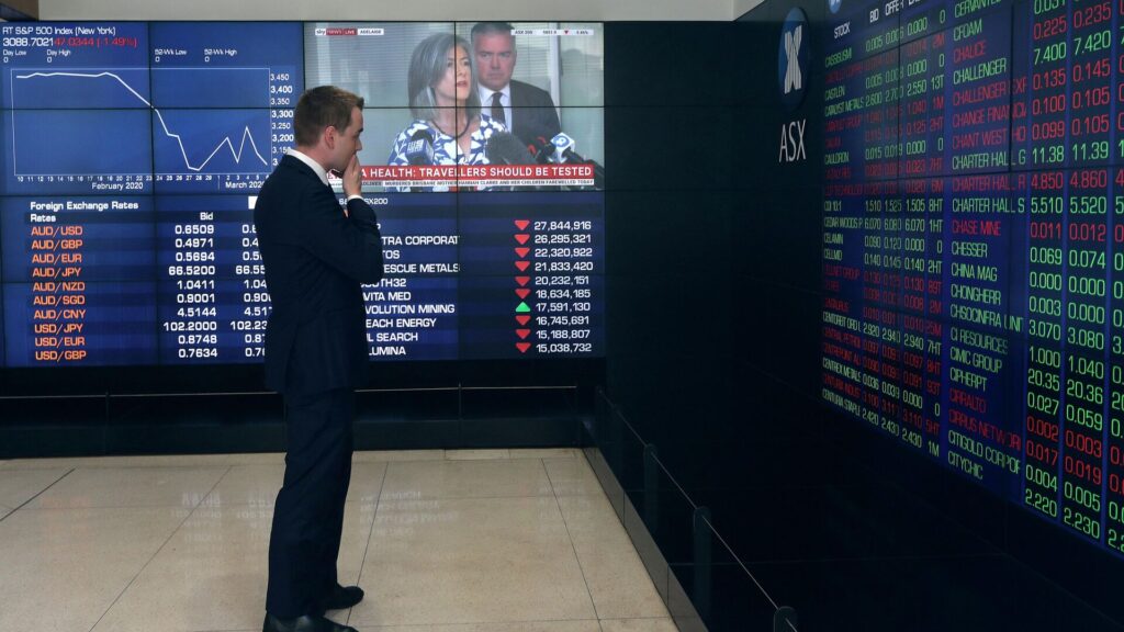Человек смотрит на табло с фондовыми индексами