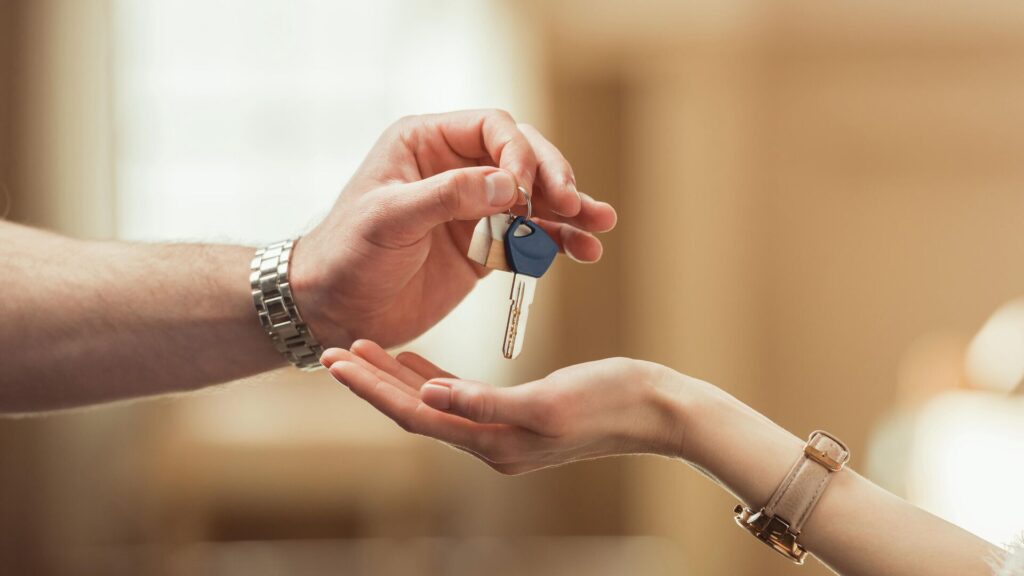 Человек дает ключи от квартиры другому человеку