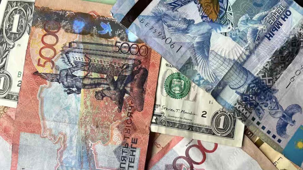 Деньги - тенге лежат рядом с долларом
