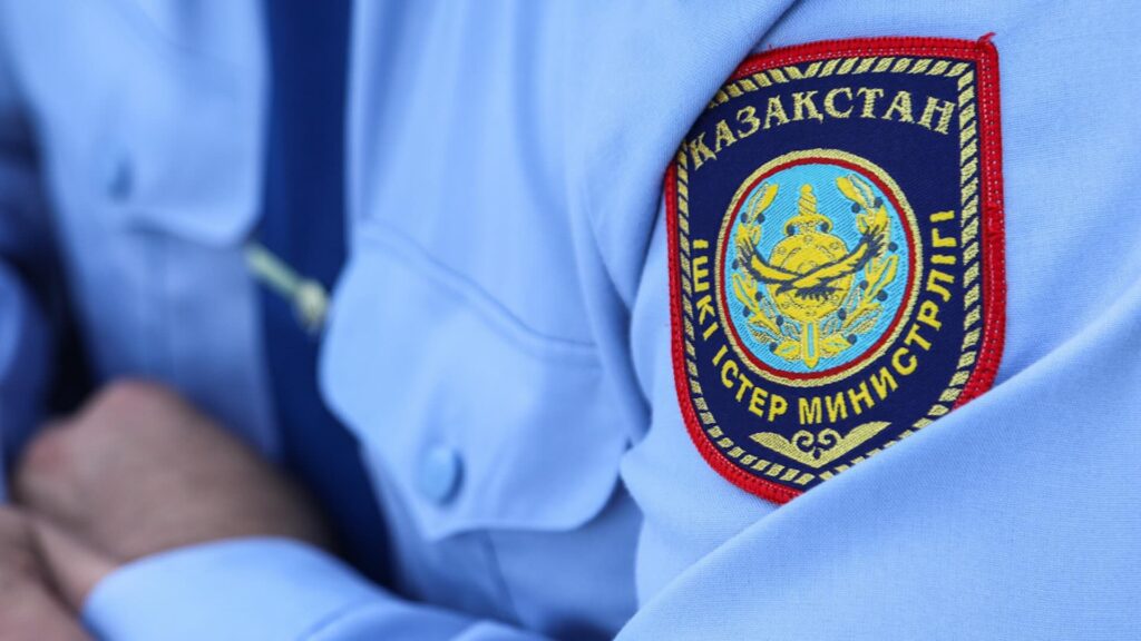 Сотрудник полиции Казахстана в рубашке с отличительным знаком