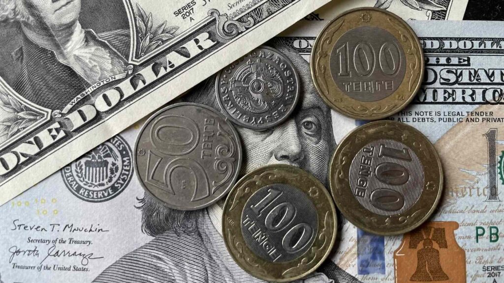 Доллар США окружен монетами тенге