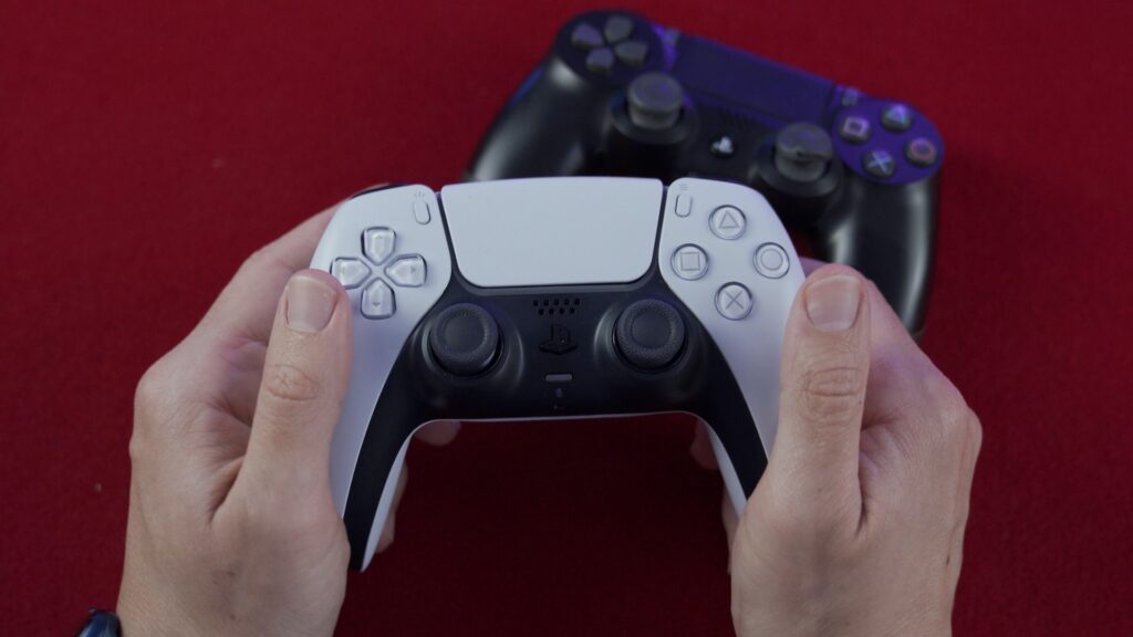 Игроман держит джойстик от игровой приставки от Sony - Play Station
