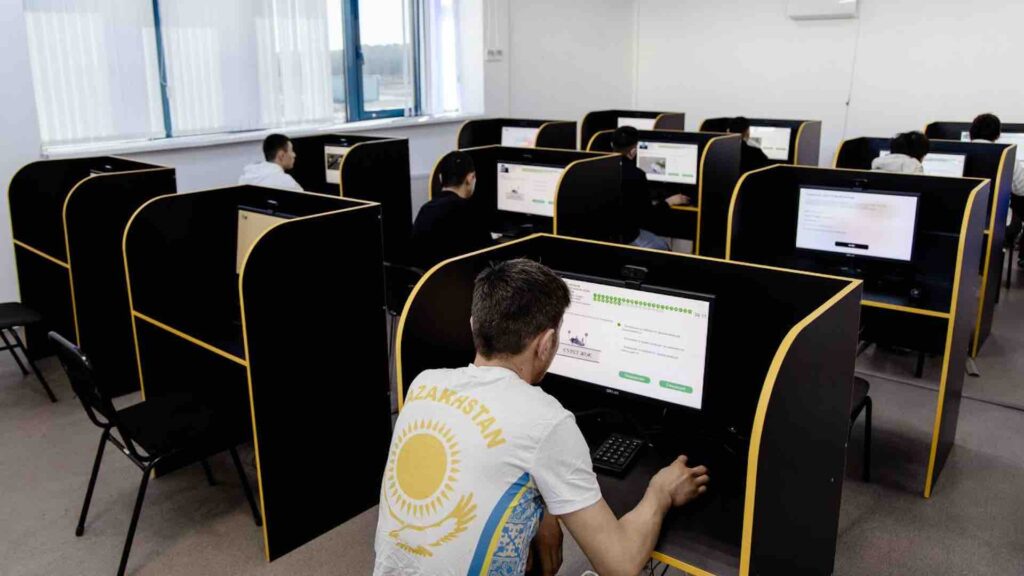 Люди сидят за комьютерами и сдают экзамены на получение водительских прав