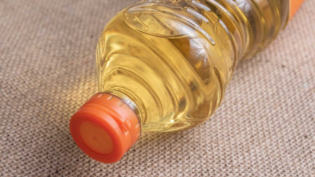 Бутылка подсолнечного масла лежит на столе