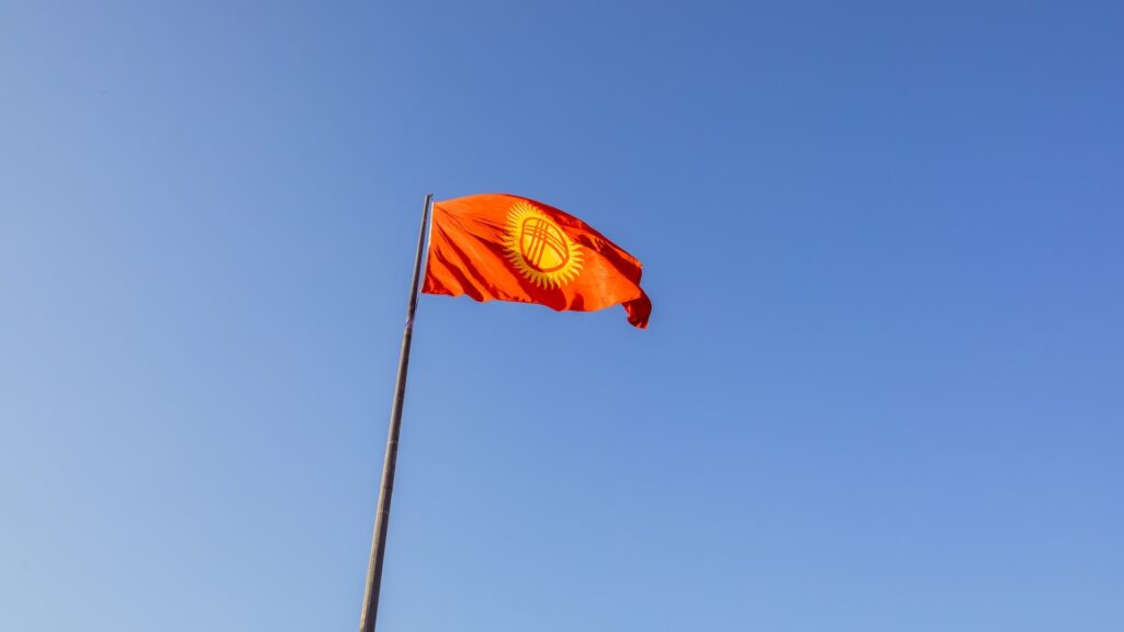 Флаг Кыргызстана на фоне синего и ясного неба