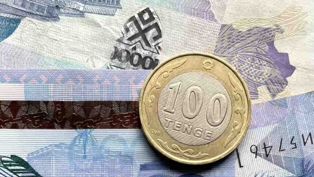 Монета в 100 тенге лежит на купюрах в 10 000 тенге