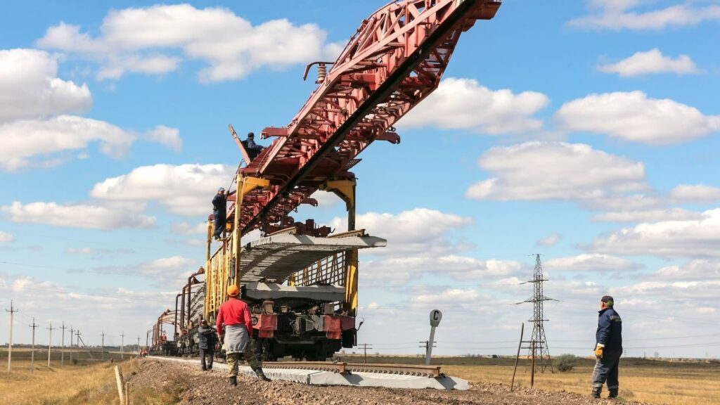 Процесс стройительства железной дороги - специализированный поезд привез шпалы для укладки