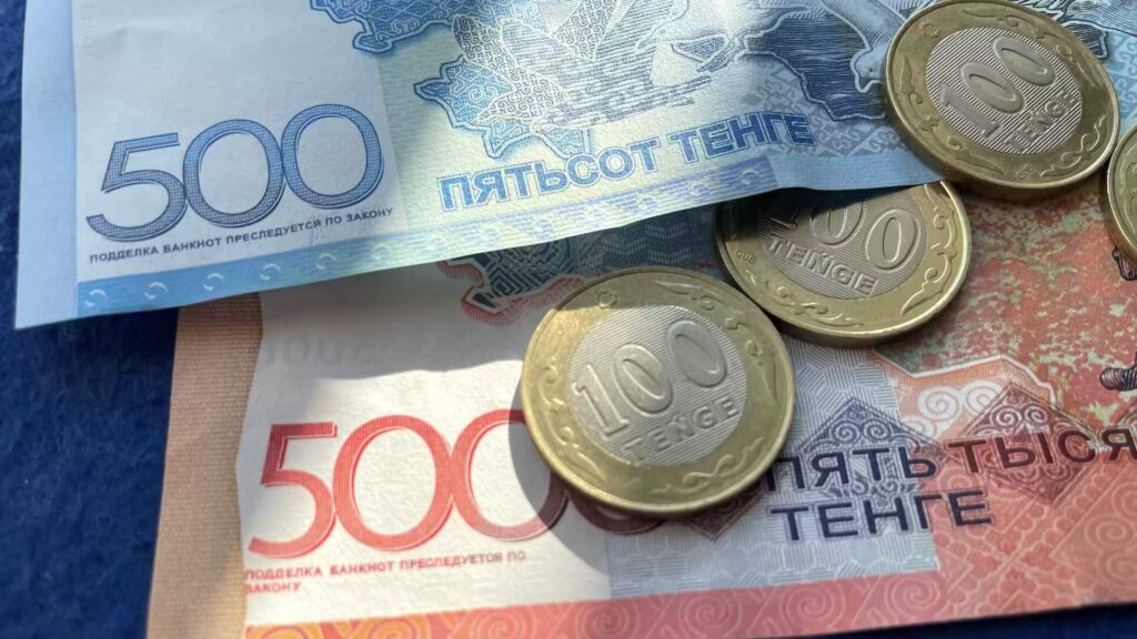 Казахстанская валюта в бумажном виде и в виде монет на столе