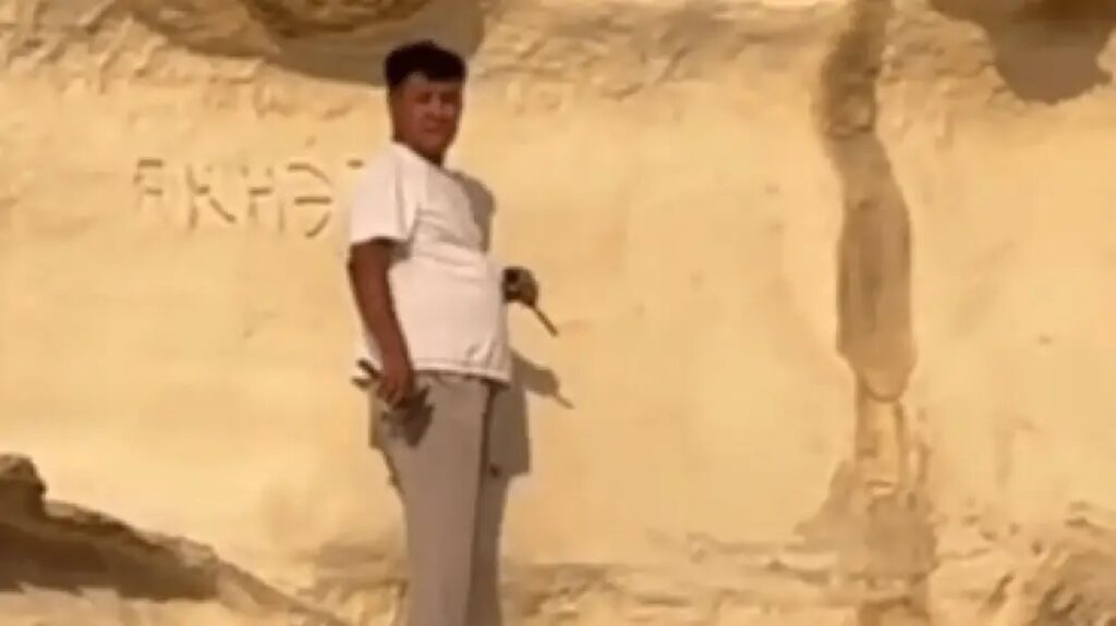 Чиновник Манас Кошербаев оставляет надпись на скале в Ыбыкты-Сай