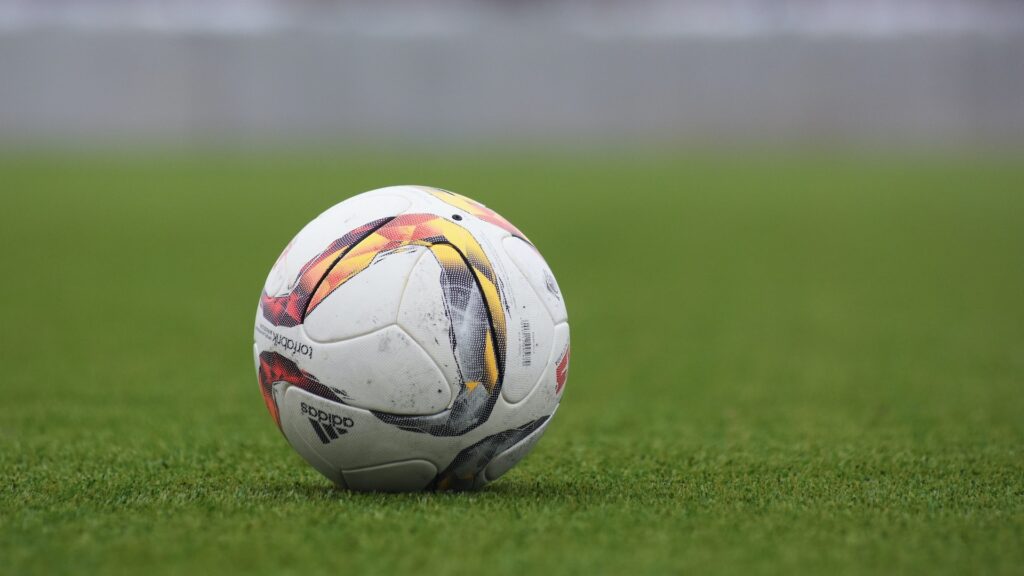 Футбольный мяч на газоне поля