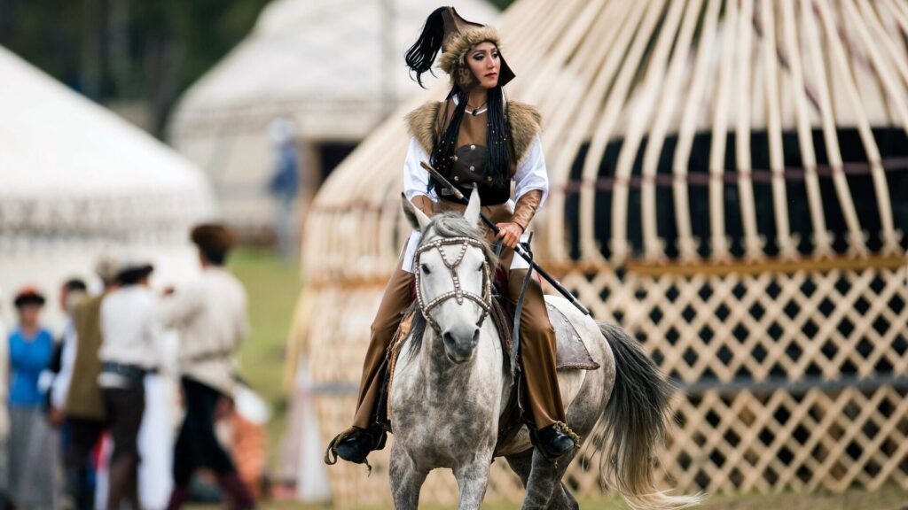 Женщина верхом на коне на Играх кочевников в Кыргызстане