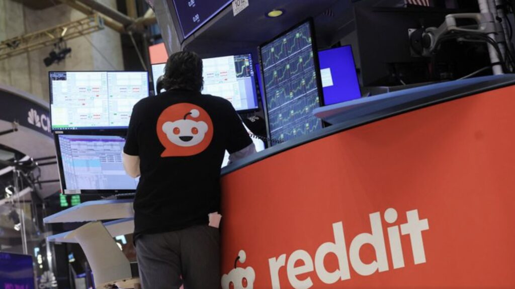 Трейдер в футболке с логотипом Reddit на Нью-Йоркской фондовой бирже (NYSE) в Нью-Йорке, США.