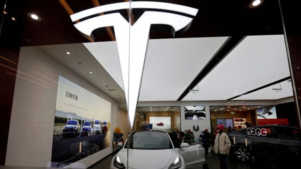 Посетители осматривают автомобиль Tesla Model 3 рядом с Model Y, выставленным в демонстрационном зале американского производителя электромобилей (EV) в Пекине, Китай