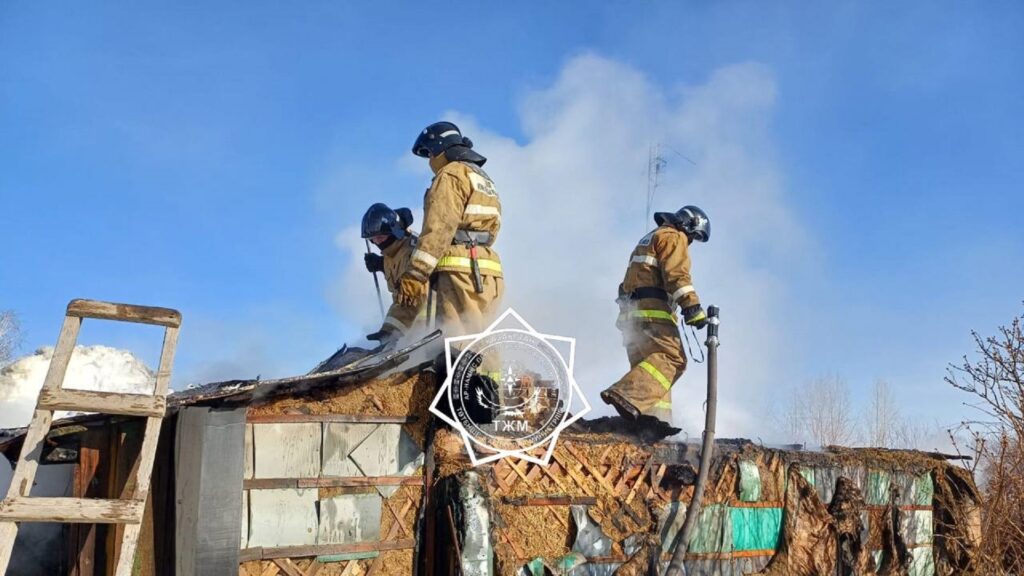 Трое пожарных на крыше горящего сарая