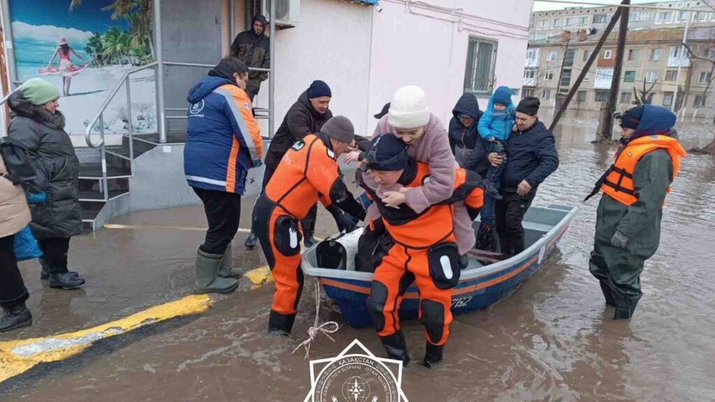 Спасатель переносит на себе девушку во время паводков в Кокшетау