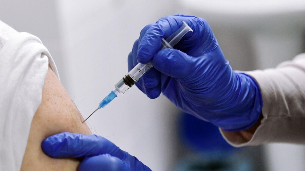 Медик ставит вакцину пациенту