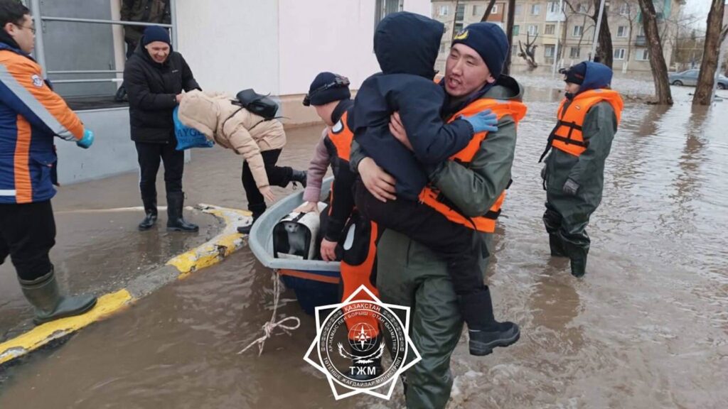 Спасатели на руках несут людей, которых спасли от паводков