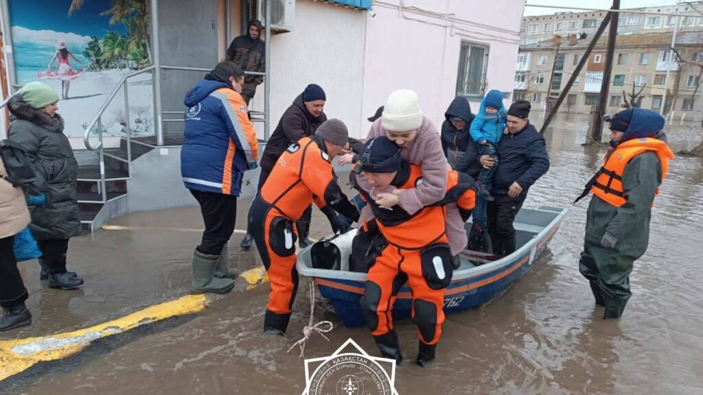 Сотрудник МЧС тащит на спине женщину, спасая ее от наводнения