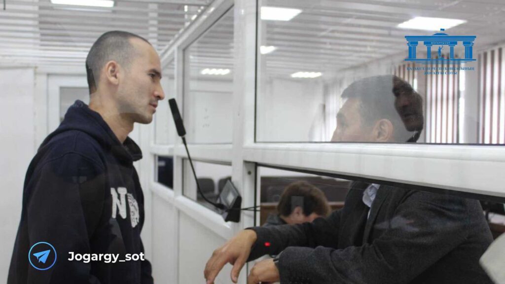 Подсудимый Дархан Ахметжанов говорит с адвокатом в зале суда