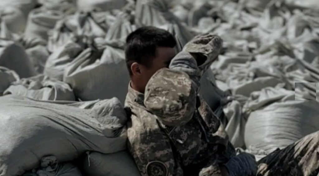 Солдат Армии Казахстана отдыхает после работы над дамбой от паводков