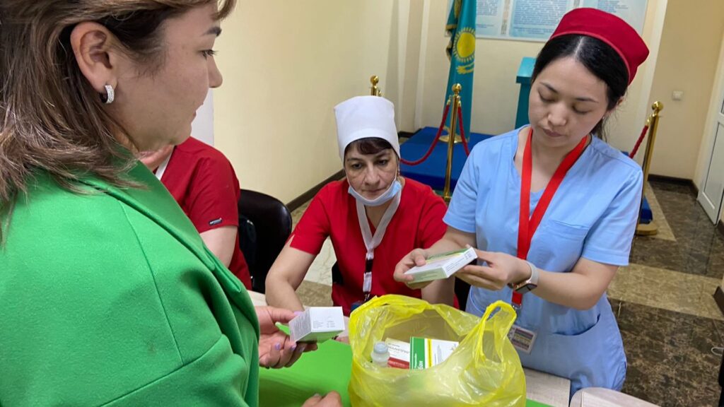 Женщина сдает просроченные лекарства в медицинское учреждение в Алматы