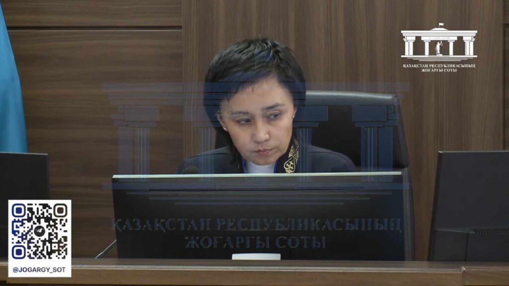 Судья Айжан Кульбаева сидит на кресле в зале суда
