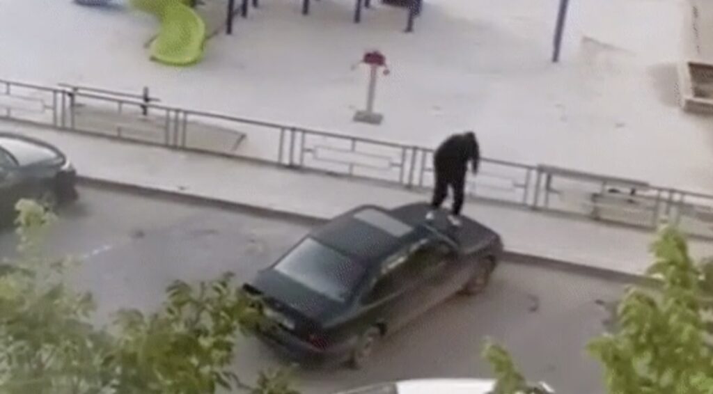 Мужчина прыгает на чужом автомобиле