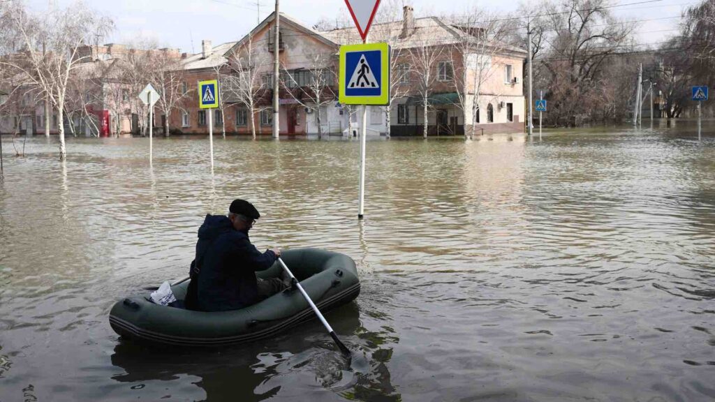 Мужчина плывет на надувной лодке по одной из затопленных улиц Орска