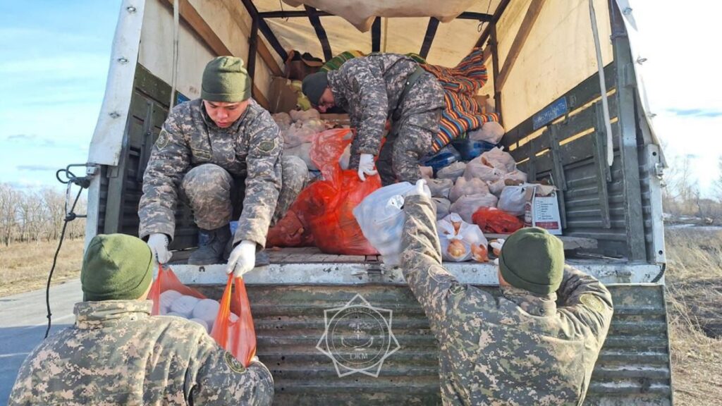 Волонтеры грузят гуманитарную помощь в машину