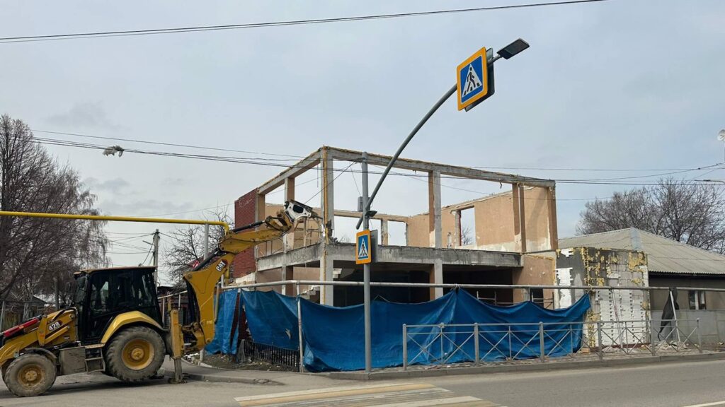 Экскаватор сносит незаконную постройку в Алматы
