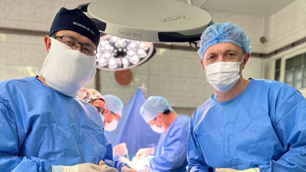 Хирурги в масках на фоне идущей операции