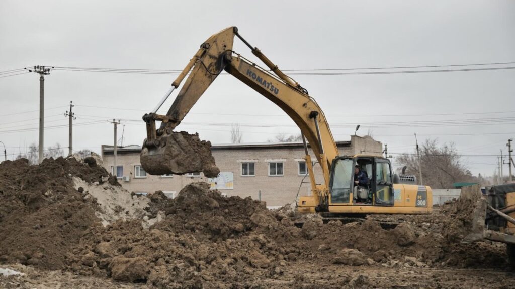 Экскаватор капает землю