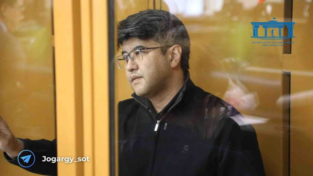 Куандык Бишимбаев в очках сидит на скамье подсудимых в суде
