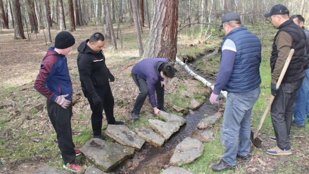 Люди укрепляют родник в национальном парке