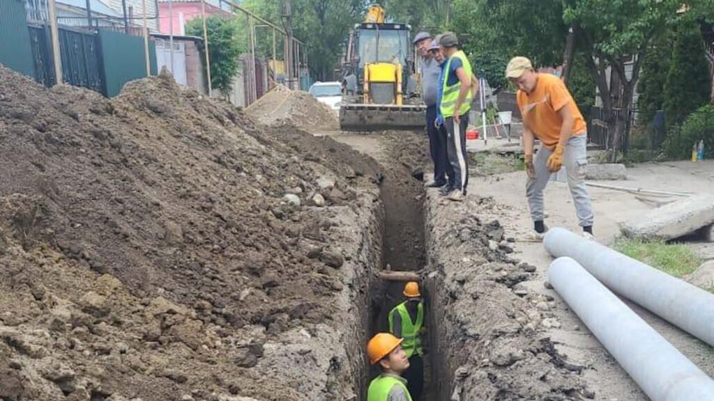 Сотрудники в яме для укладки труб канализации и водоснобжения