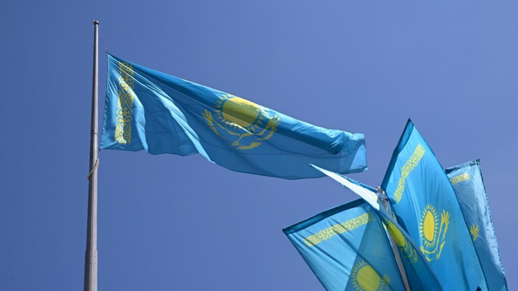 Флаг Казахстана на фоне синего неба