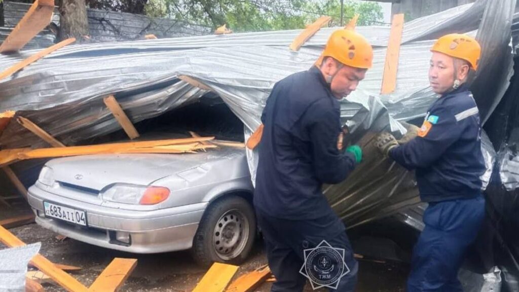 Двое спасателей разбирают крышу с машины