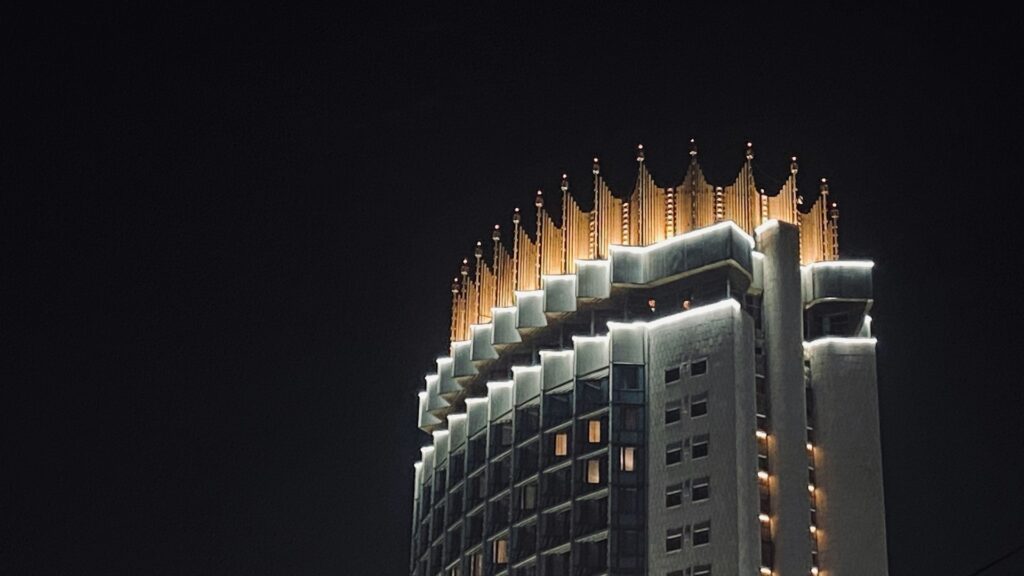 Верхние этажи гостиницы Казахстан в Алматы на фоне черного неба